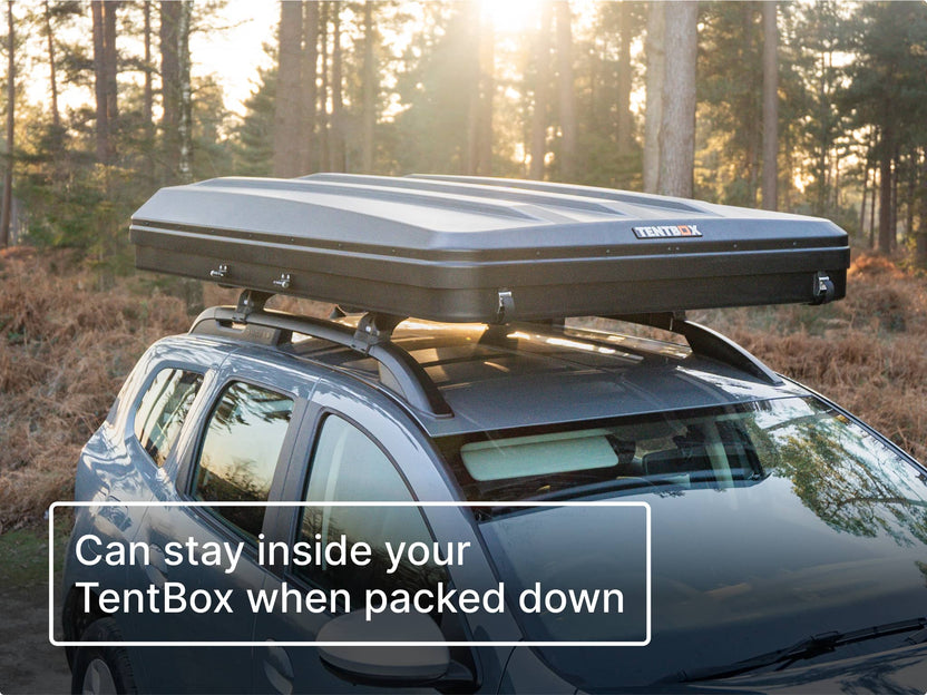 Car with a closed TentBox on the roof in a forest setting. Text reads 'can stay inside your TentBox when packed down'.