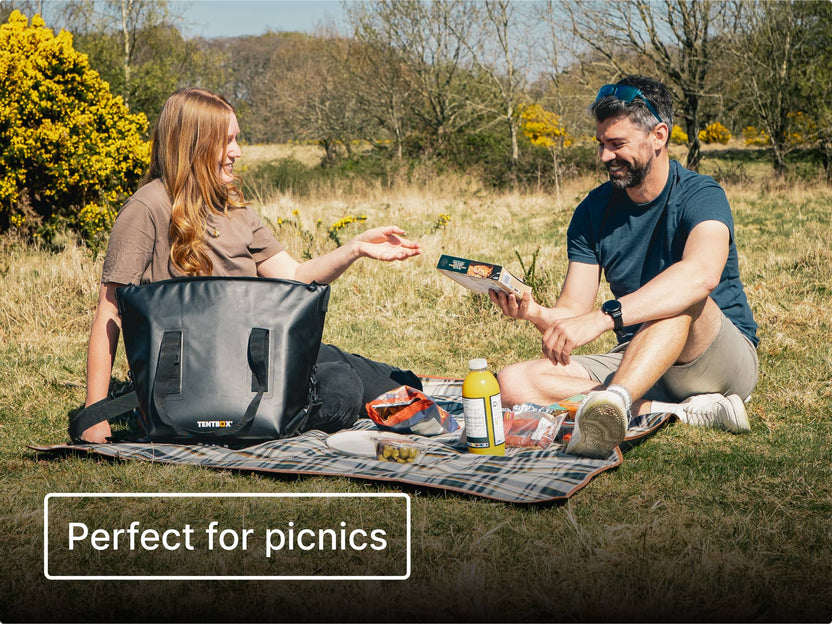 Two people sitting on a picnic blanket in a park with the TentBox CoolBag and text 'Perfect for picnics'.