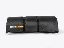 Rolled-up TentBox Lite XL Mattress Topper with branded storage straps – compact and easy to pack