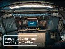 TentBox interior with Lite Storage Pockets hanging neatly from the roof, with the integrated tablet holder with the Disney+ logo clearly visible. Text reads 'Hangs neatly from the roof of your TentBox.'
