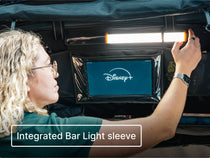 Person installing the LED Bar Light in the Storage Pocket compartment, with a tablet inside the tablet holder visibly showing the Disney+ logo. Text overlay reads 'Integrated Bar Light sleeve'.