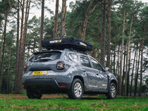 ATCLI - TentBox Lite 1.0 Travel Cover installed on a grey car in the woods